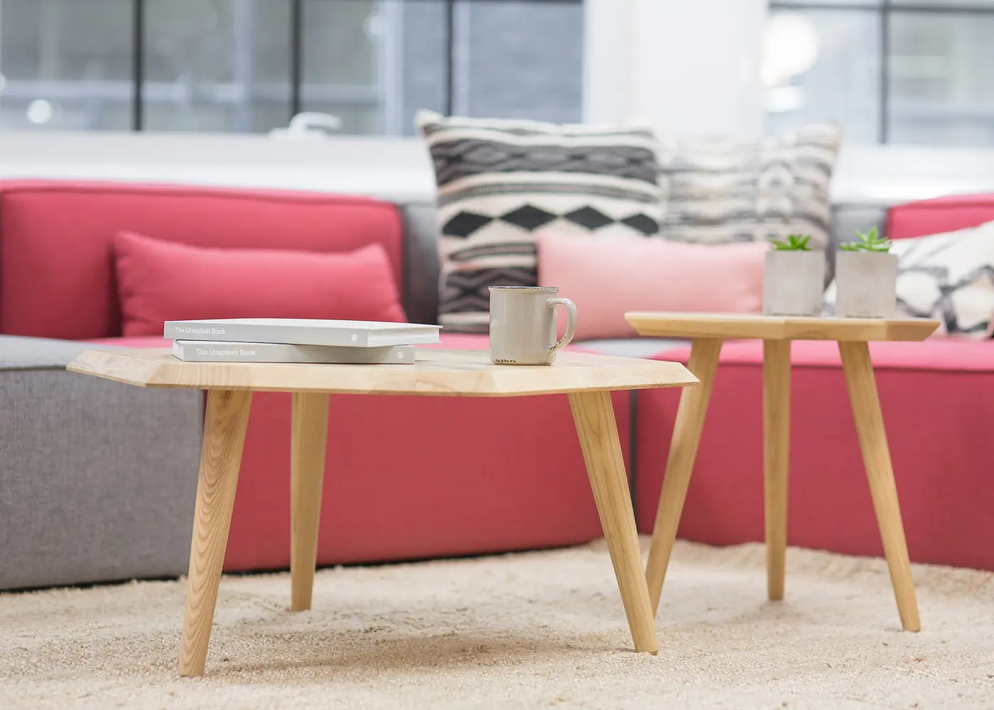 Tables basses en bois devant un canapé rose